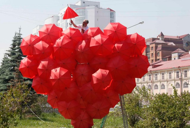 Artista ruso Vasily Slonov termina su obra "Corazón Rojo", que consta de unos 80 paraguas, en la víspera de la apertura de la 4 º festival de música Krasnoyarsk Internacional de la región de Asia-Pacífico en la ciudad siberiana de Krasnoyarsk (Foto Reuters Iiya Naymushin) 