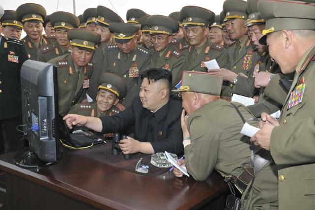 Fotografía de archivo facilitada por la Agencia Norcoreana (KCNA) el pasado 27 de abril de 2014 que muestra al líder norcoreano, Kim Jong-un (centro), observando una pantalla de ordenador junto a una multitud de soldados en Corea del Norte. El servicio de internet en Corea del Norte se restauró hoy, martes 23 de diciembre de 2014, tras sufrir cortes intermitentes en varias páginas de medios oficiales durante unas nueve horas, un incidente que se produce después del anuncio de EE.UU. de que respondería "de forma proporcionada" al ciberataque a Sony Pictures Entertainment. EFE/Kcna