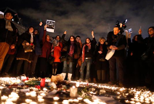 Foto: Las personas sostienen plumas y lápices en una vigilia , después de los disparos de 12 personas en el periódico satírico Charlie Hebdo , en la Plaza de la República en París / Reuters