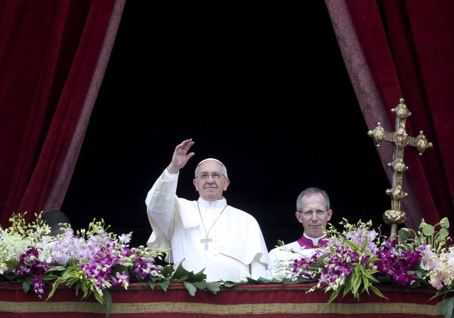 Pope Francis waves as he delivers a "Urbi et Orbi" message from the balcony overlooking St. Peter's Square at the Vatican