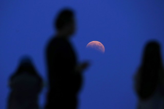 The beginning of a total lunar eclipse is seen from the Qizhong Tennis Court in Shanghai