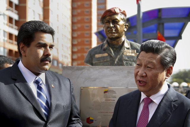 El presidente de China, Xi Jinping (R), habla con el presidente de Venezuela, Nicolás Maduro, frente a una estatua del difunto presidente de Venezuela, Hugo Chávez, durante una ceremonia en Caracas en esta foto de archivo del 21 de julio de 2014 /REUTERS / Carlos Garcia Rawlins