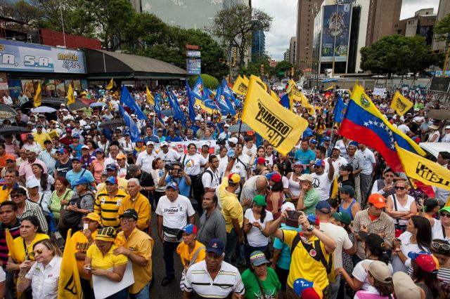 CAR01. CARACAS (VENEZUELA), 08/08/2015.- Decenas de personas asisten a una manifestación hoy, sábado 8 de agosto de 2015, en la ciudad de Caracas (Venezuela). La alianza opositora venezolana Mesa de la Unidad Democrática (MUD) admitió que fue escasa la asistencia a la manifestación que convocó para hoy en Caracas, pero subrayó que ello no pone en dudas el triunfo que prevé en los comicios de diciembre. La convocatoria a marchar por todas las capitales de los 24 estados del país, y por zonas del centro-este de Caracas, "contra el hambre, contra el hampa por la libertad, por la unidad", finalmente reunió a unas pocas decenas de personas en una sola calle de la capital venezolana. EFE/MIGUEL GUTIERREZ