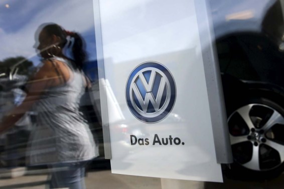 A woman is seen reflected on the window of a Volkswagen dealership in the Queens borough of New York, September 21, 2015. Volkswagen shares plunged more than 20 percent on Monday, their biggest ever one-day fall, after news that the German carmaker had rigged U.S. emissions tests, and Germany said it would investigate whether data had been falsified in Europe too. REUTERS/Shannon Stapleton