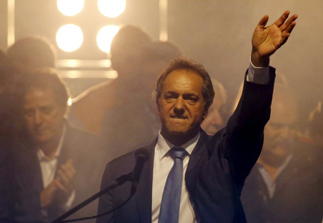 Argentina's ruling party candidate Daniel Scioli waves to supporters at the party's headquearters in Buenos Aires, October 25, 2015.  Scioli had a wide lead in Sunday's presidential election, TV exit polls showed, but his main rival's party said it was sure Scioli would fall short of an outright win and have to face a run-off.  REUTERS/Marcos Brindicci