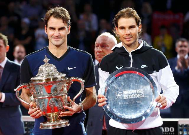 Switzerland's Roger Federer (L) holds the trophy after winning his match against Rafael Nadal of Spain at the Swiss Indoors ATP men's tennis tournament in Basel, Switzerland November 1, 2015.   REUTERS/Arnd Wiegmann