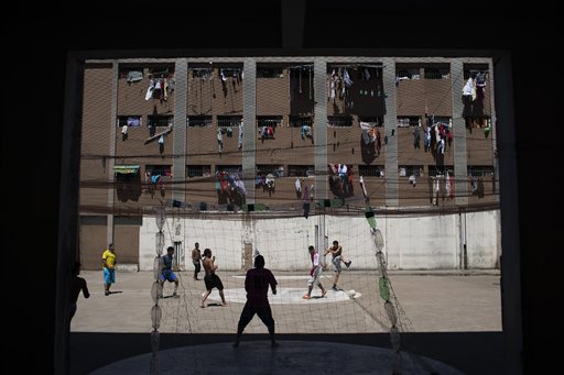 En esta imagen, tomada el 30 de noviembre de 2015, presos juegan al fútbol en la Prisión Central de Porto Alegre, Brasil, mientras las prendas de los internos cuelgan de las ventanas de sus celdas. Las instalaciones acogen al doble de reos de su capacidad, casi 2000 personas. (Foto AP/Felipe Dana)