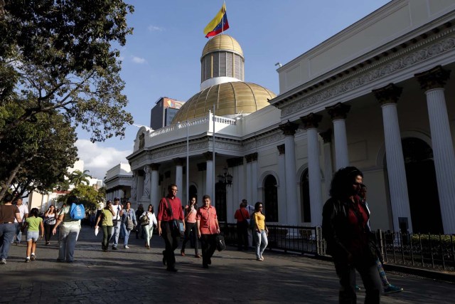 People walk past the National Assembly building during a parliamentary session in Caracas January 19, 2016. REUTERS/Carlos Garcia Rawlins