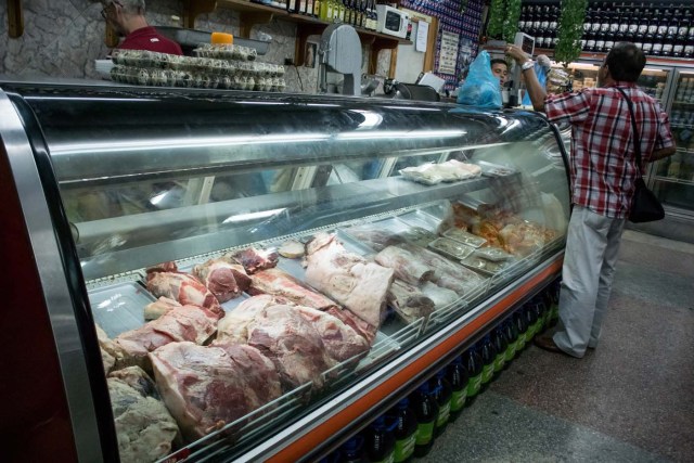 CAR13. CARACAS (VENEZUELA), 11/02/2016.- Un hombre compra carne hoy, jueves 11 de febrero de 2016, en Caracas (Venezuela). El Parlamento venezolano declaró hoy la "crisis alimentaria nacional" y en virtud de ello pidió que la FAO y la Unicef envíen expertos que evalúen los riesgos que entraña el problema para los 30 millones de habitantes del país caribeño. EFE/Miguel Gutiérrez