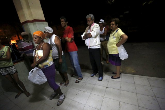 People stand in line to buy freshly baked bread outside a bakery in Havana, Cuba March 17, 2016. Obama arrives in Havana on Sunday for a historic visit that seals a rapprochement he and Cuban President Raul Castro agreed in December 2014 after 18 months of secret negotiations. REUTERS/Claudia Daut SEARCH "OBAMA CUBA" FOR THIS STORY. SEARCH "THE WIDER IMAGE" FOR ALL STORIES.