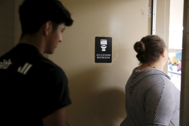 Johnny Ramos, 18, (L) and Monique Garcia, 17, walk out of the first gender-neutral restroom in the Los Angeles school district at Santee Education Complex high school in Los Angeles, California, U.S., April 18, 2016. REUTERS/Lucy Nicholson