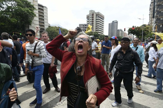 Demonstrators protest against new emergency powers decreed this week by President Nicolas Maduro in Caracas on May 18, 2016.  Public outrage was expected to spill onto the streets of Venezuela Wednesday, with planned nationwide protests marking a new low point in Maduro's unpopular rule. / AFP PHOTO / JUAN BARRETO