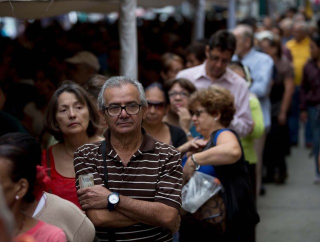 La gente hace fila para certificar sus firmas en la sede del Consejo Nacional Electoral de Venezuela, CNE, en Caracas, Venezuela, el lunes 20 de junio de 2016. Para activar una nueva etapa del proceso del referendo revocatorio del mandato del presidente Nicolás Maduro, la oposición debe lograr la validación de al menos 196.000 firmas. De superarse esta etapa la oposición deberá emprender la recolección de más de cuatro millones de firmas para lograr activar formalmente la consulta popular. (Foto AP / Fernando Llano)