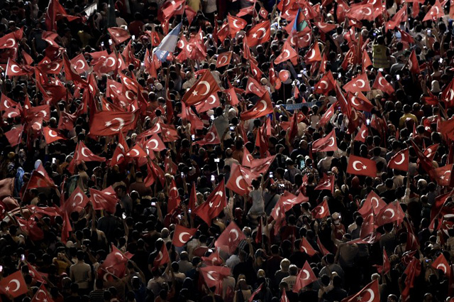 A Pro-Erdogan supporters hold Turkish national flags during a rally at Taksim square in Istanbul on July 18, 2016 following the military failed coup attempt of July 15. Turkish security forces on July 18 carried out new raids against suspected plotters of the botched coup against the rule of President Recep Tayyip Erdogan, as international concern grew over the scale of the crackdown. Thousands of pro-Erdogan supporters waving Turkish flags filled the main Kizilay Square in Ankara while similar scenes were seen in Taksim Square in Istanbul, AFP photographers said. / AFP PHOTO / ARIS MESSINIS