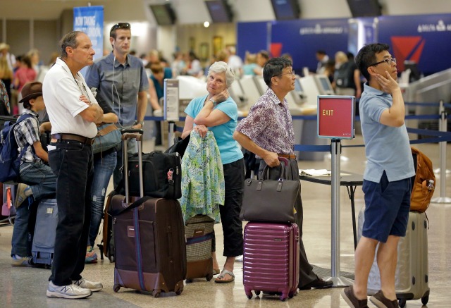 Pasajeros de la aerolínea Delta hacen fila mientras esperan su vuelo tras un fallo informático que afectó a las operaciones de la empresa en todo el mundo a principios de semana, el 9 de agosto de 2016, en Salt Lake City, Utah. (AP Foto/Rick Bowmer)