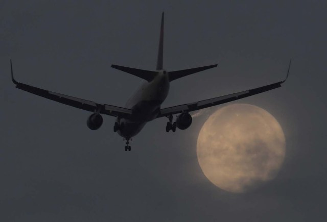 A passenger aircraft makes it's landing approach to Heathrow airport in front of a "super moon" at dawn in west London, Britain, October 17, 2016. REUTERS/Toby Melville TPX IMAGES OF THE DAY