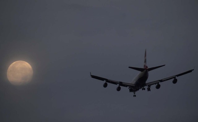 A passenger aircraft makes it's landing approach to Heathrow airport in front of a "super moon" at dawn in west London, Britain, October 17, 2016. REUTERS/Toby Melville