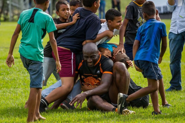 ACOMPAÑA CRÓNICA: VENEZUELA CÁRCELES. CAR15. REVENGA (VENEZUELA), 19/11/2016.- Un recluso de la cárcel Rodeo II comparte con niños después de un partido de rugby este viernes, 18 de noviembre de 2016, en una hacienda de la empresa de ron Santa Teresa, en Revenga (Venezuela). En Venezuela, un país sin tradición de rugby y donde la población reclusa tiene pocas probabilidades de reinserción social, se celebra un torneo que burla tales estadísticas y que pone en el campo de juego a decenas de presos que experimentan así una sensación de libertad. EFE/Miguel Gutiérrez