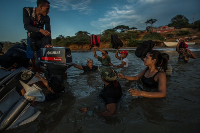 Emigrantes venezolanos embarcando en un bote de contrabandistas que los llevará hasta la isla de Curazao. Credit Meridith Kohut para The New York Times