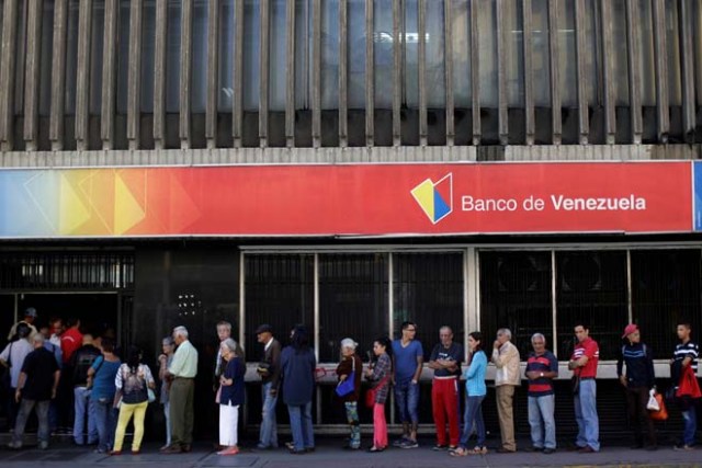 People line up to withdraw cash from a Banco de Venezuela branch in Caracas, Venezuela December 2, 2016. REUTERS/Ueslei Marcelino