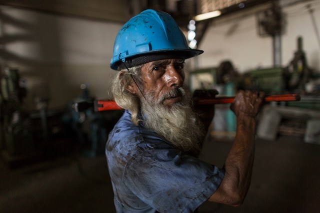 En esta foto del 29 de octubre de 2016, José Noriega, mecánico en un barco atunero de 66 años, se detiene para hacerle un retrato en la empresa estatal pesquera Pescalba, en Cumaná, estado de Sucre, Venezuela. El gobierno nacionalizó Pescalba en 2010. (AP Foto/Rodrigo Abd)