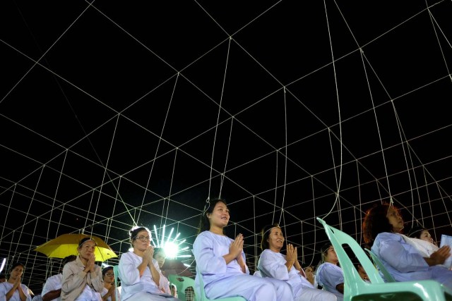 Thais pray to celebrate the 2017 new year at a temple in Hua Hin, Thailand, December 31, 2016. Strings attached are ceremonial threads given by Buddhist monk. REUTERS/Athit Perawongmetha