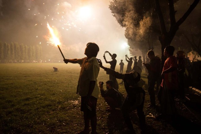 A man holds a spankler at the Bajra Sandhi Monument during New Year celebrations in Denpasar, Bali island, Indonesia January 1, 2017. REUTERS/Agung Parameswara FOR EDITORIAL USE ONLY. NO RESALES. NO ARCHIVES