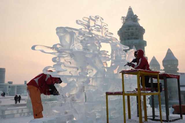 En esta imagen, tomada el 3 de enero de 2017 y distribuida por la agencia china de noticias Xinhua, dos participantes tallan una escultura de hielo durante el concurso de esculturas del  Festival Internacional de Hielo y Nueve de Harbin, en la provincia de Heilongjiang, en el noreste de China. La ciudad de Harbin, en el gélido noreste de China, da los últimos retoques previos a la apertura de uno de los festivales de hielo más grandes del mundo, que el año pasado atrajo a más de un millón de visitantes. (Wang Jianwei/Xinhua via AP)