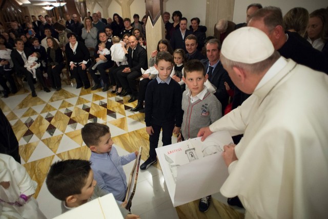 Pope Francis receives a drawing depicting the village of Amatrice during a ceremony to baptise 13 babies coming from the earthquake zone of Amatrice at the Vatican January 14, 2017. Osservatore Romano/Handout via REUTERS ATTENTION EDITORS - THIS IMAGE WAS PROVIDED BY A THIRD PARTY. EDITORIAL USE ONLY. NO RESALES. NO ARCHIVE.