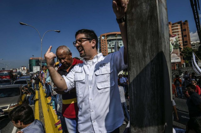 Venezuela's National Assembly first Vice-President, opposition Freddy Guevara (C), takes part in a protest at the main highway of Caracas on January 24, 2017. Venezuelan opponents protested to demand early elections, with the aim of ousting President Nicolas Maduro, who they blame for the profound political and economic crisis that has the country in its grip. / AFP PHOTO / JUAN BARRETO