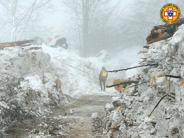 Rescue workers inspect a cleared road by the site of the avalanche-buried Hotel Rigopiano in Farindola, central Italy, hit by an avalanche, in this undated picture released on January 24, 2017 provided by Alpine and Speleological Rescue Team. Soccorso Alpino Speleologico Lazio/Handout via REUTERS ATTENTION EDITORS - THIS IMAGE WAS PROVIDED BY A THIRD PARTY. EDITORIAL USE ONLY. NO RESALES. NO ARCHIVE. TPX IMAGES OF THE DAY