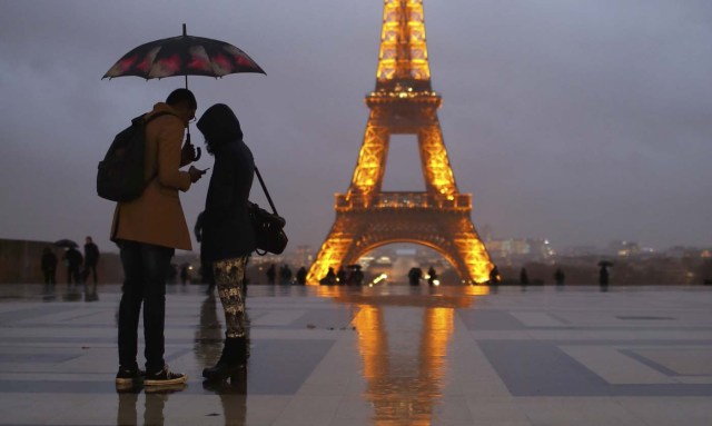 People protect themselves from the rain under umbrellas at Trocadero Square near the Eiffel Tower in Paris, France, January 12, 2017. REUTERS/Gonzalo Fuentes