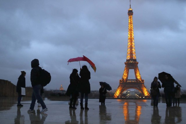 People protect themselves from the rain under umbrellas at Trocadero square near the Eiffel Tower in Paris, France, January 12, 2017. REUTERS/Gonzalo Fuentes