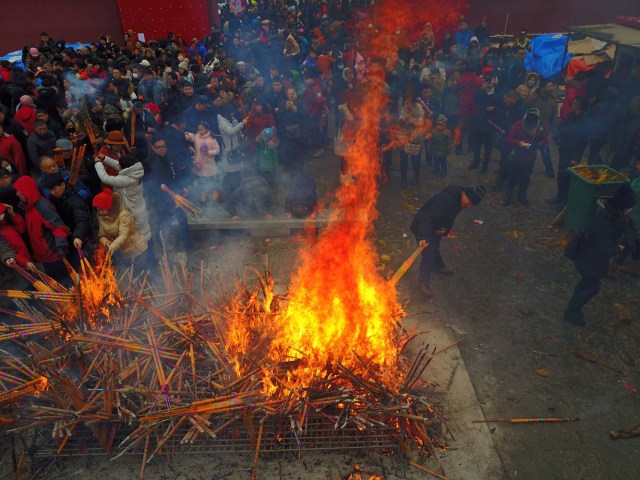 People pray with incense sticks at a temple fair as they celebrate the Lunar New Year in Shenyang, Liaoning province, China, January 28, 2017. REUTERS/Sheng Li CHINA OUT. NO COMMERCIAL OR EDITORIAL SALES IN CHINA