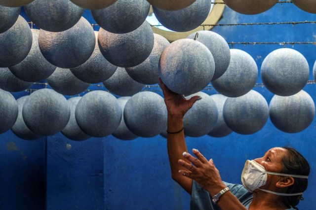 A worker handles inner tubes of footballs at a ball factory in Mongui, in the Colombian department of Boyaca, on February 13, 2017. Mongui, in the central mountains of Colombia, has about 20 football factories that make balls mainly for football and micro-football. About a quarter of the town's 4,900 inhabitants work in these factories. / AFP PHOTO / Luis ACOSTA
