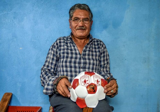 Worker Jose Sierra sews a football by hand at a ball factory in Mongui, in the Colombian department of Boyaca, on February 13, 2017. Mongui, in the central mountains of Colombia, has about 20 ball factories that make balls mainly for football and micro-football. About a quarter of the town's 4,900 inhabitants work in these factories. / AFP PHOTO / Luis ACOSTA
