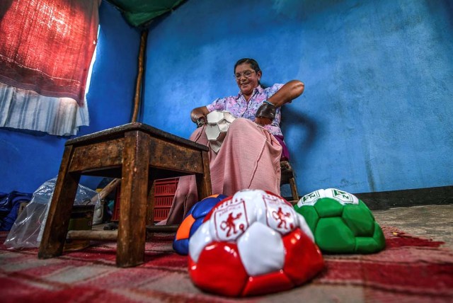 Worker Vitalina Mesa sews a football by hand at a ball factory in Mongui, in the Colombian department of Boyaca, on February 13, 2017. Mongui, in the central mountains of Colombia, has about 20 football factories that make balls mainly for football and micro-football. About a quarter of the town's 4,900 inhabitants work in these factories. / AFP PHOTO / Luis ACOSTA