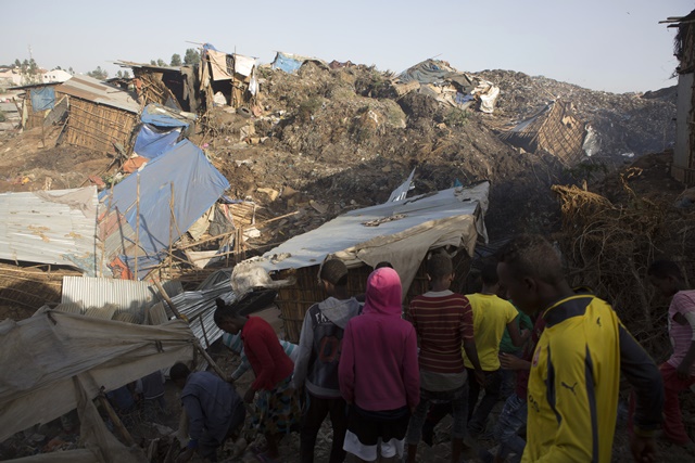 People look at the damage done to dwellings built near the main landfill of Addis Ababa on the outskirts of the city on March 12, 2017, after a landslide left at least 30 people dead. At least 30 people died and dozens more were hurt in a giant landslide at Ethiopia's largest rubbish dump outside Addis Ababa, a tragedy squatters living there blamed on a biogas plant being built nearby. The landslide late on March 11 saw dozens of homes of people living in the dump levelled after a part of the largest pile of rubbish at the Koshe landfill collapsed, an AFP journalist said. / AFP PHOTO / ZACHARIAS ABUBEKER