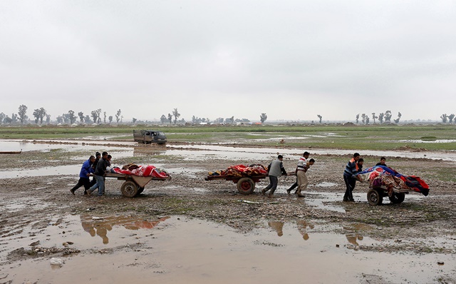 Familiares cargando los cuerpos de los muertos en ataques aéreos en Mosul