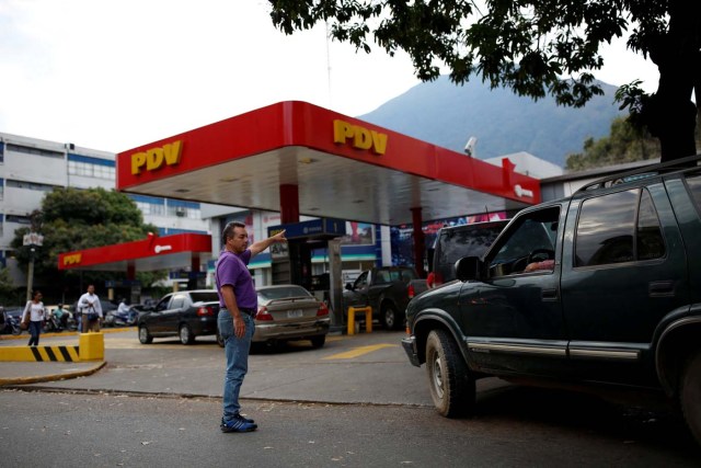 A man tries to organize the queue of car waiting to fill the tanks at a gas station of the state oil company PDVSA in Caracas, Venezuela March 22, 2017. REUTERS/Carlos Garcia Rawlins