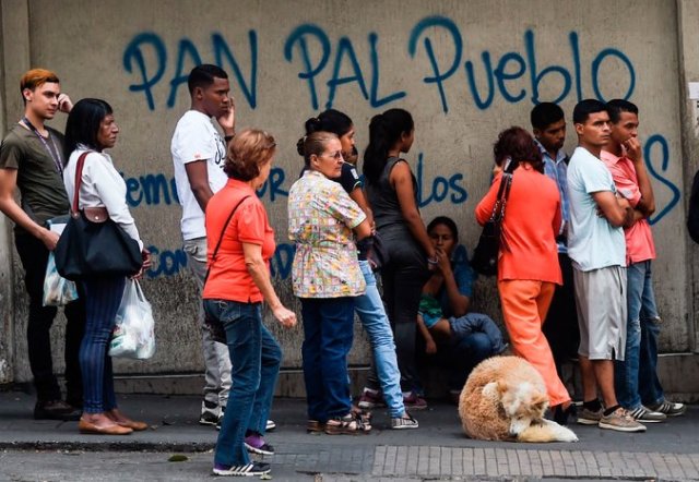 Gente haciendo cola para comprar pan fuera de una panadería en Caracas el 17 de marzo de 2017. Credit Juan Barreto/Agence France-Presse 
