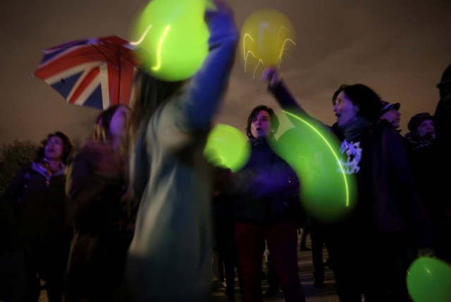 People play with lit balloons after the lights were switched off for Earth Hour at the Royal Palace in Madrid, Spain, March 25, 2017. REUTERS/Susana Vera