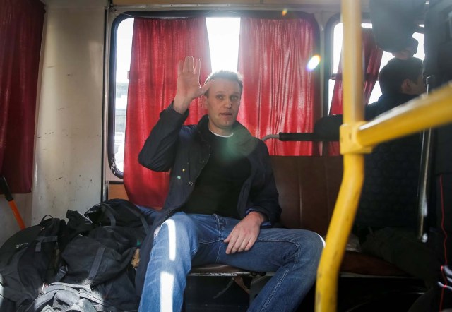 Anti-corruption campaigner and opposition figure Alexei Navalny waves as he sits inside a police van after after being detained during a rally in Moscow, Russia, March 26, 2017. REUTERS/Maxim Shemetov