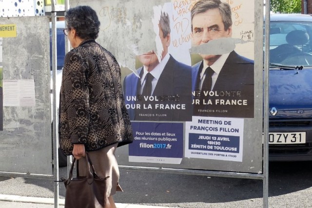 This picture taken in Toulouse on April 18, 2017, shows an electoral poster of French presidential election candidate for the right-wing Les Republicains (LR) party Francois Fillon defaced. / AFP PHOTO / PASCAL PAVANI