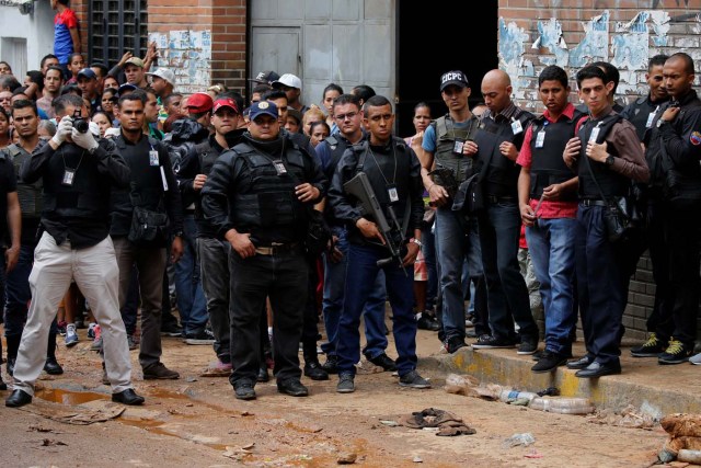 Police officers and criminal investigators look for evidence in front of a bakery, after it was looted in Caracas, Venezuela April 21, 2017. REUTERS/Carlos Garcia Rawlins