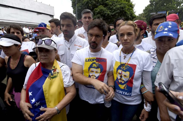 Lilian Tintori (R), wife of jailed Venezuelan opposition leader Leopoldo Lopez, prepares to take part in a march towards the Catholic Church's episcopal seats nationwide, in Caracas, on April 22, 2017. Venezuelans gathered Saturday for "silent marches" against President Nicolas Maduro, a test of his government's tolerance for peaceful protests after three weeks of violent unrest that has left 20 people dead. / AFP PHOTO / JUAN BARRETO