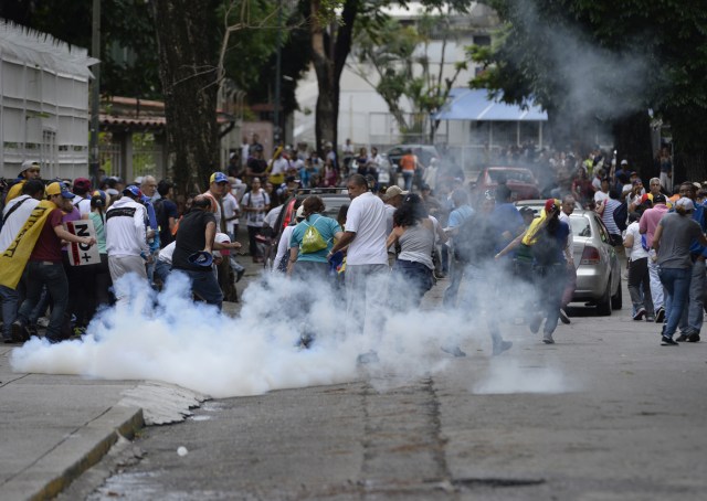 Venezuelan opposition activists clash with the police during a march against President Nicolas Maduro, in Caracas on May 1, 2017. May Day protests risk being rough in Venezuela as it marks one month since deadly clashes erupted in a political crisis with no end in sight. Protesters took to the streets from April 1 to demand elections after the courts tried to strengthen President Nicolas Maduro's grip on power. / AFP PHOTO / FEDERICO PARRA
