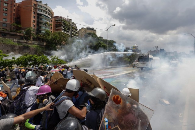 CAR46. CARACAS (VENEZUELA), 10/05/2017 - Manifestantes se enfrentan a la Guardia Nacional Bolivariana hoy, miércoles 10 de mayo de 2017, en Caracas (Venezuela). Efectivos de las fuerzas de seguridad del Estado venezolano dispersaron hoy con gas lacrimógeno la manifestación de la oposición que pretendía llegar hasta la sede del Tribunal Supremo de Justicia. EFE/CRISTIAN HERNÁNDEZ