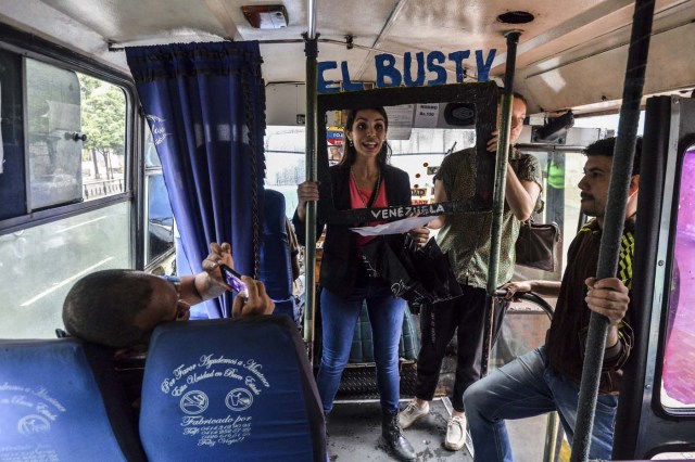 Maria Gabriela Fernandez (C) gives a presentation of the Bus TV news in Caracas, Venezuela, on June 6, 2017. A group of young Venezuelan reporters board buses to present the news, as part of a project to keep people informed in the face of what the opposition and the national journalists' union describe as censorship by the government of Nicolas Maduro. / AFP PHOTO / LUIS ROBAYO