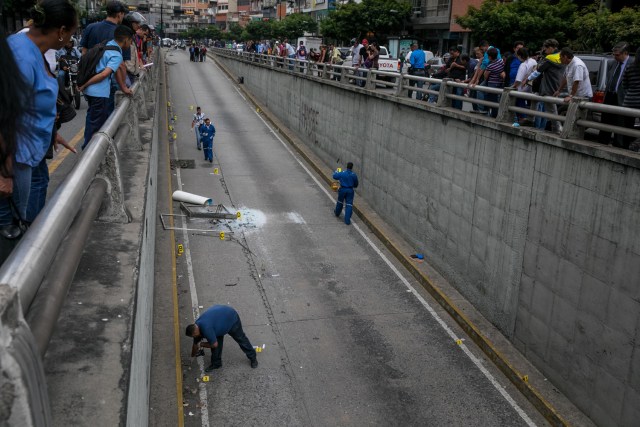 CAR26. CARACAS (VENEZUELA), 08/06/2017 - Trabajadores del Ministerio Público realizan hoy, jueves 8 de junio de 2017, el levantamiento planimétrico en el lugar en el que un joven de 17 años murió durante una protesta opositora, en Caracas (Venezuela). El Ministerio Público venezolano (MP, Fiscalía) cifró hoy en 67 las muertes registradas en hechos violentos relacionados con las protestas a favor y en contra del Gobierno de Nicolás Maduro que sacuden la nación desde hace 69 días. EFE/MIGUEL GUTIÉRREZ